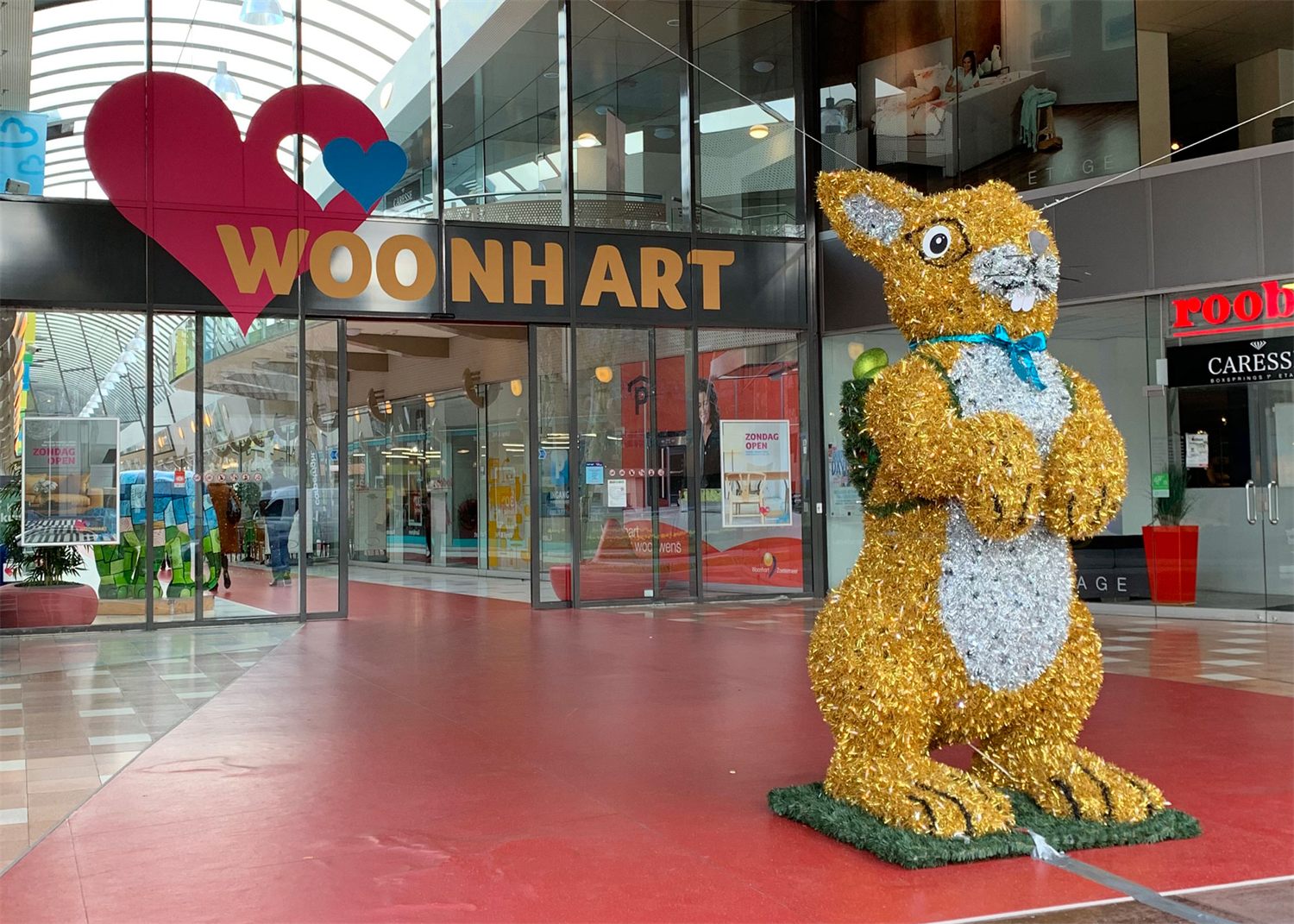 Gouden paashaas voor de entree van een winkelcentrum